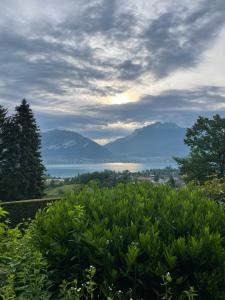 a view of a lake with mountains in the distance at Les Rochers du lac in Cessenaz