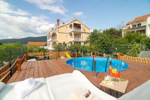 a backyard with a swimming pool and a house at Adriatic Guest House Milić in Gornji Karin