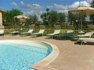 a pool with chairs and tables and umbrellas at Agriturismo Le Rose in Pescia Romana
