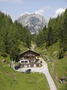 a large building on a hill with a mountain in the background at Glösalm in Ramsau am Dachstein