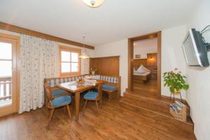 a dining room with a table and chairs and a television at Glösalm in Ramsau am Dachstein