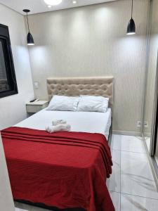 une chambre avec un lit avec une couverture rouge dans l'établissement Apartamento, Centro SP - Piscina e Ar Condicionado, à São Paulo