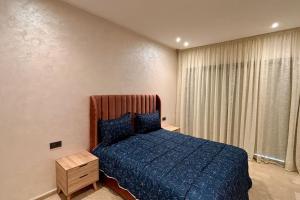 a bedroom with a blue bed and a window at Luxury Appart Tamaris - Piscine Jardin et Plage à Pied in Tamaris +18 photos
