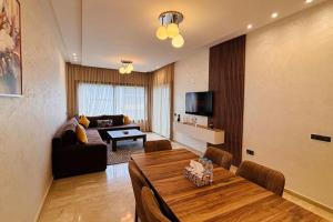 a living room with a table and a couch at Luxury Appart Tamaris - Piscine Jardin et Plage à Pied in Tamaris