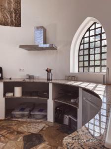 a kitchen with a counter and an arched window at Finca Caprichosa in Cortelazor