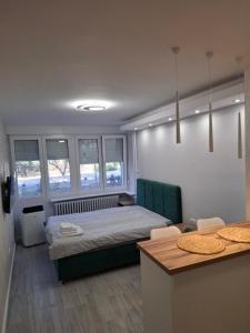 a bedroom with a bed and a table and some windows at Arena New Belgrade by Magenta in Novi Beograd