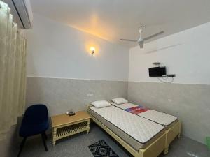 兰奇Bimala Hotel的一间带床、椅子和电视的卧室