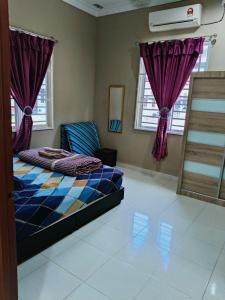 a bedroom with a bed with purple curtains at Homestay Kampung Lubuk Buaya 2 Bedrooms in Pantai Cenang +8 photos