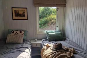 ein Schlafzimmer mit zwei Einzelbetten und einem Fenster in der Unterkunft Buavollen in Vågbø