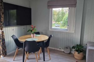 ein Tisch und Stühle in einem Zimmer mit Fenster in der Unterkunft Buavollen in Vågbø