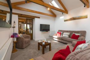 a living room with two couches and a tv at Pilgrims Barn in Hayle