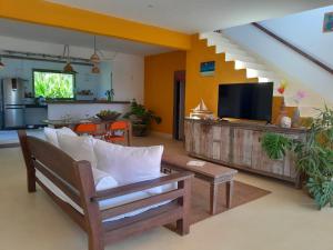un soggiorno con un divano e una TV di Casa Trancoso perto quadrado praia a Porto Seguro