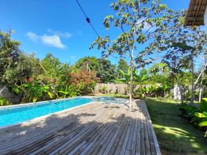 un cortile con piscina e terrazza in legno di Casa Trancoso perto quadrado praia a Porto Seguro