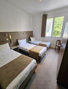 a hotel room with two beds and a window at Adonis Lourdes - Notre Dame de la Sarte in Lourdes
