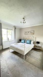 ein Schlafzimmer mit einem weißen Bett mit blauen Kissen in der Unterkunft Gatelodge - Charming 2-Bed Cottage, Exmouth - Sleeps 3 in Exmouth