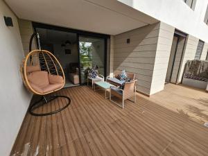 a porch with a chair and a swing on a house at Superbe Appartement Green Town in Oulad Lahsene +6 photos