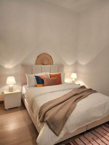 Ash ShumaysānīにあるGoga Apartment in Jabal Amman near Rainbow Streetのベッドルーム1室(大型ベッド1台、ランプ2つ付)