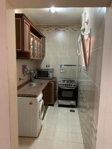 a small kitchen with a sink and a stove at Paradise residence in Dumyāţ al Jadīdah