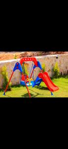 a red and blue play structure in the grass at Villa simurg in Kas
