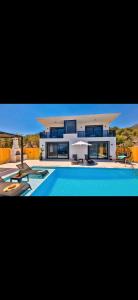 a large house with a swimming pool in front of it at Villa simurg in Kas