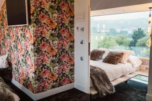 桑提亚纳德玛Hotel Cuevas - Adults Only的一间卧室配有花卉壁纸和一张带窗户的床