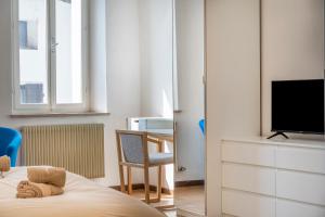 a bedroom with a bed and a tv and a desk at Cividale Medieval Town Apartment in Cividale del Friuli