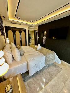 a bedroom with a large bed and a television at Centre Zara 2BR in Marrakech