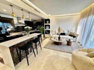 a living room with a kitchen and a living room with a table at Ultra-Luxury 2-Bedroom Apartment in City Center Atlas View in Marrakesh