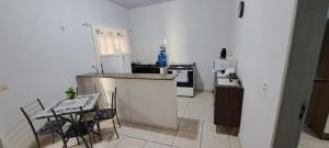 a kitchen with a counter and a table and chairs at Flat Jm 02 in Parauapebas