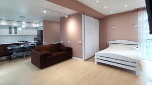 a bedroom with a bed and a couch and a kitchen at Apartments - studio Katarina in K'obulet'i