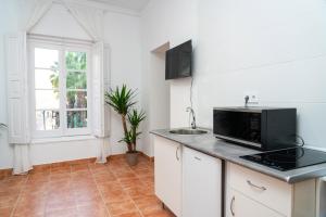 a kitchen with a microwave and a sink at Centro apartamento 2-D in Huelva
