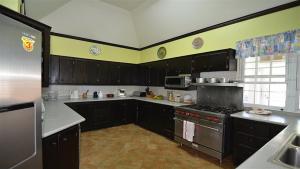 een keuken met zwarte kasten en een fornuis met oven bij Spicy Hill Villa in Port Antonio