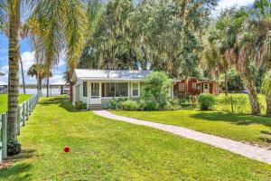 a small white house with palm trees in the yard at Nature's Nest Lake House in Lake Wales +42 photos