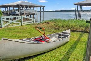 a boat sitting on the grass next to the water at Nature's Nest Lake House in Lake Wales