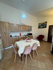 a kitchen with a table and some pink chairs at La vie en rose in Santa Maria degli Angeli