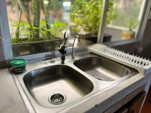 a kitchen sink with a faucet next to a window at Casa Manglares Capurganá in Acanti +25 photos
