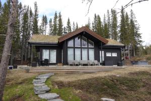 a house with a large deck with tables and chairs at Hytte ved Andsvatnet in Bardufoss