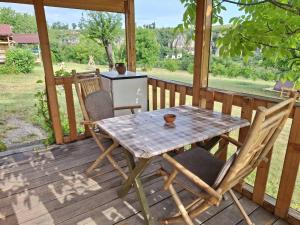 a table and chairs on a porch with a computer at Ecopark Sadzhaka in Basarbovo