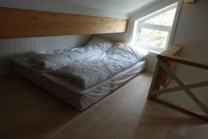 a bed in the corner of a room with a window at Hytte ved Andsvatnet in Bardufoss