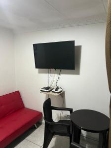 a living room with a red couch and a flat screen tv at Guadual 101 in La Victoria