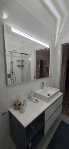 un bagno con un lavandino e un grande specchio di Ca' Olivo a Mogliano Veneto Altre 37 foto