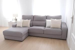 een grijze bank met kussens in de woonkamer bij Corazón Cuatro in Jaén