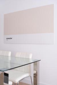 een glazen tafel en witte stoelen in een kamer bij Corazón Cuatro in Jaén