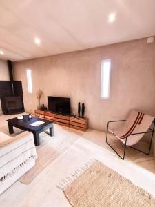 a living room with a couch and a tv at Comporta, maison de plage in Comporta