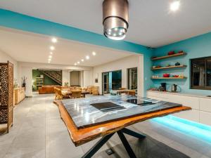 a kitchen and living room with blue walls and a table at Little Forest Garden Retreat in Windhoek +26 photos