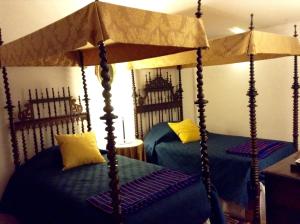 a bedroom with two canopy beds with blue sheets and yellow pillows at Casa de Sao Cosmado in Mangualde +22 photos