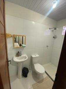 a white bathroom with a toilet and a sink at Temporada BHS Quarto 1 in Barreirinhas