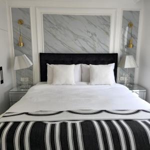 a bedroom with a large white bed with two lamps at Luxury apartment, kilimani in Nairobi