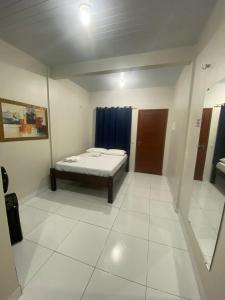 a small room with a bed and a mirror at Temporada BHS Quarto 2 in Barreirinhas