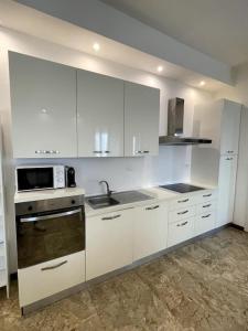 a kitchen with white cabinets and a sink and a microwave at The modern House in Mantova +16 photos